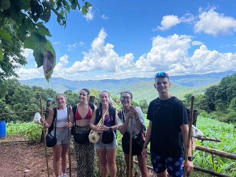 Group of people posing with a scenic mountain backdrop.
