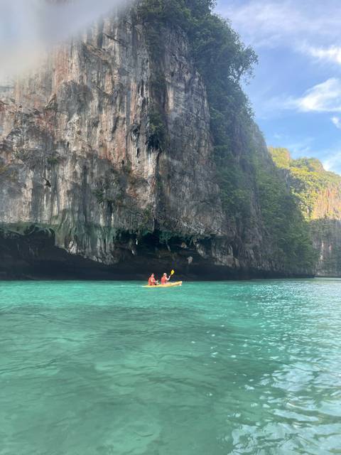 Couple kayaking near limestone cliffs.