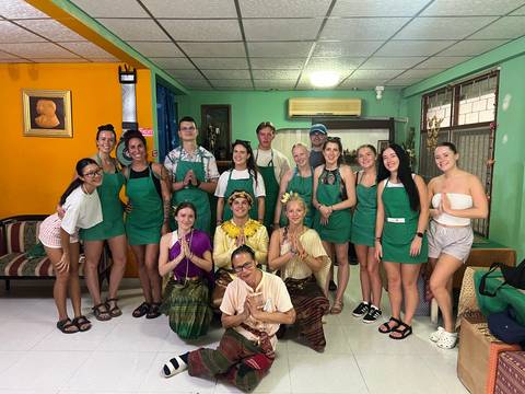 Group of people in cooking class posing together.