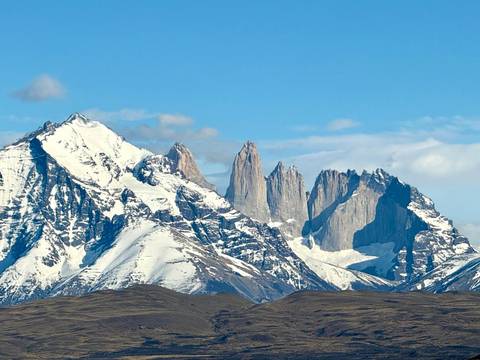 A majestic view of snow-capped mountains under a clear sky.
