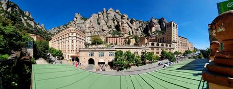 A monastery complex set against a rugged mountain backdrop.
