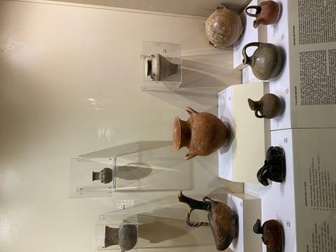       Close-up of various pottery artifacts in a museum display.
  