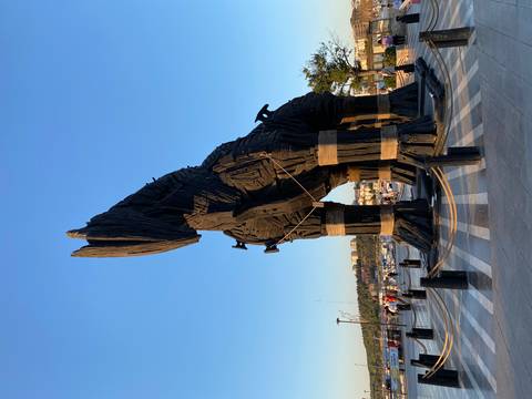 Trojan Horse sculpture with people around.