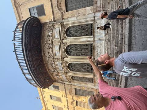 People admiring a historical ornate facade.