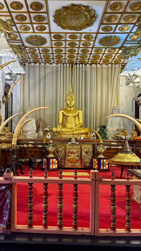 Interior of a temple with a golden statue and decorations.
