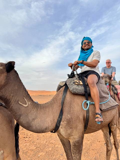 Tourists riding camels in the desert.