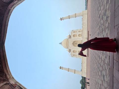 Silhouette of a person dancing in front of the Taj Mahal archway.