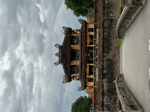       Traditional house with ornate carvings under a cloudy sky.
  