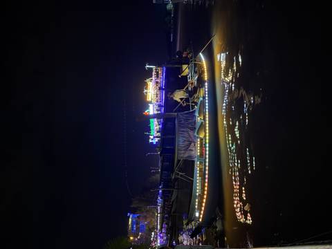       Boat with lanterns floating in a night setting.
  
