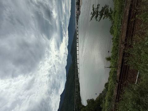       River scene with a bridge and distant mountains.
  