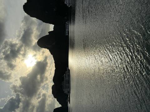       Sunset view of Halong Bay with silhouetted islands.
  