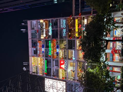       Colorful building with neon signage at night.
  