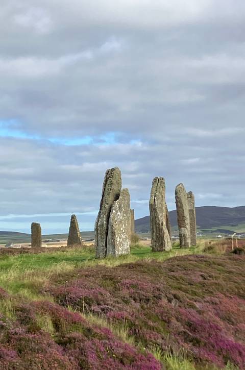 Stone circle with standing stones in a rural setting.