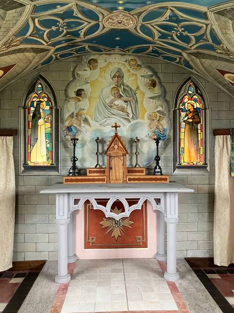 Chapel interior with altar and stained glass windows.