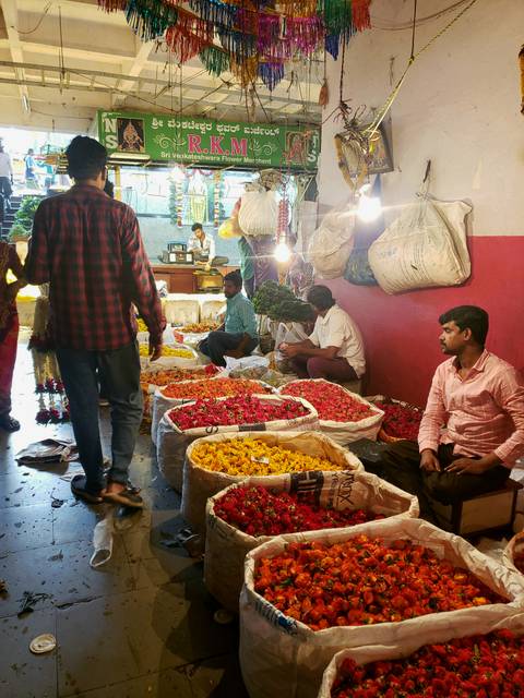 A market scene with vendors selling colorful flowers.