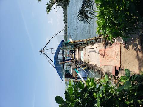 A traditional Chinese fishing net on a pier by the water.