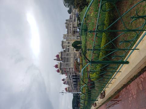 Mysore Palace with well-maintained gardens and ornate architecture.