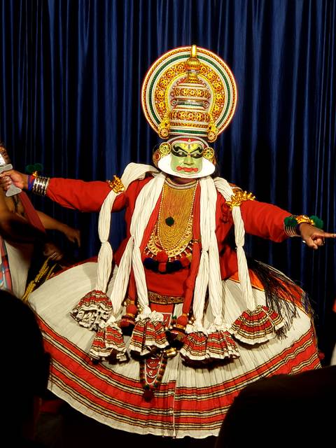 A traditional Kathakali dancer in full costume with expressive makeup.