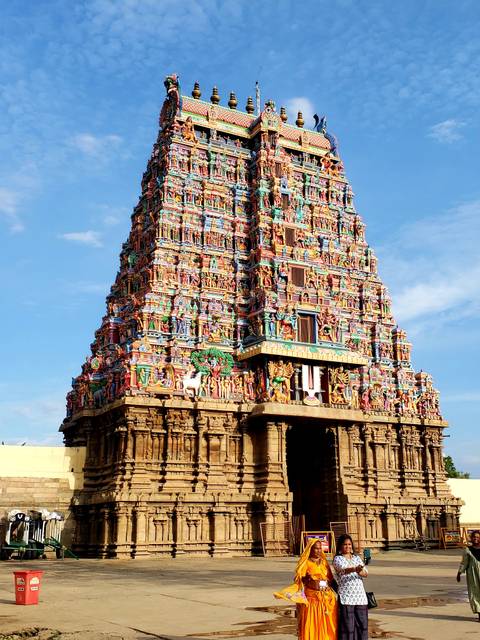       An intricately carved and colorful gopuram of a Hindu temple.
  