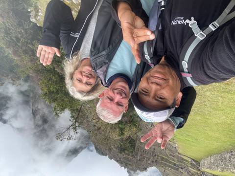      Tourists taking a selfie outdoors surrounded by mist.
  