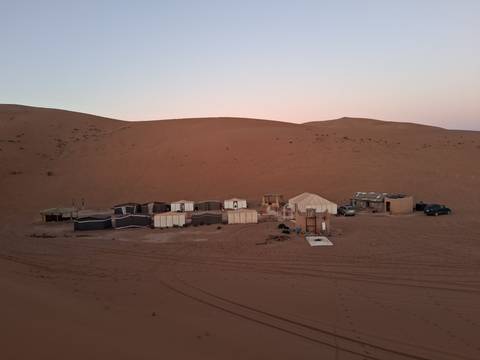 Desert campsite with tents during twilight.