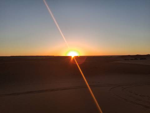 Sunset over desert dunes.