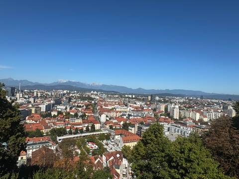 Panoramic view of a city with mountainous backdrop.