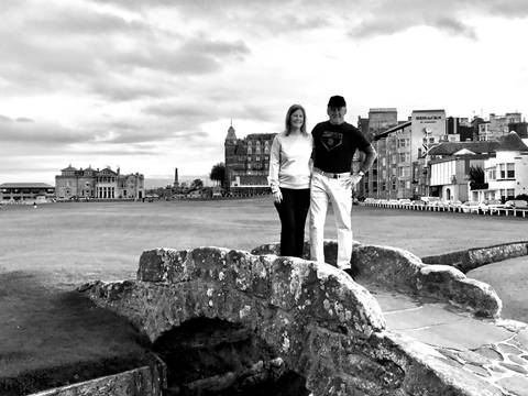 Two people standing on a historic stone bridge.