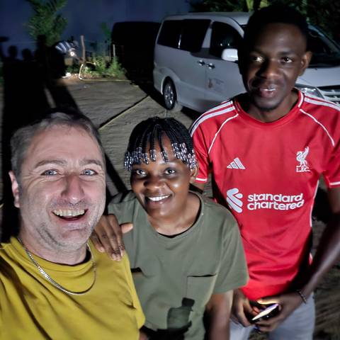 Selfie of three people smiling at night.