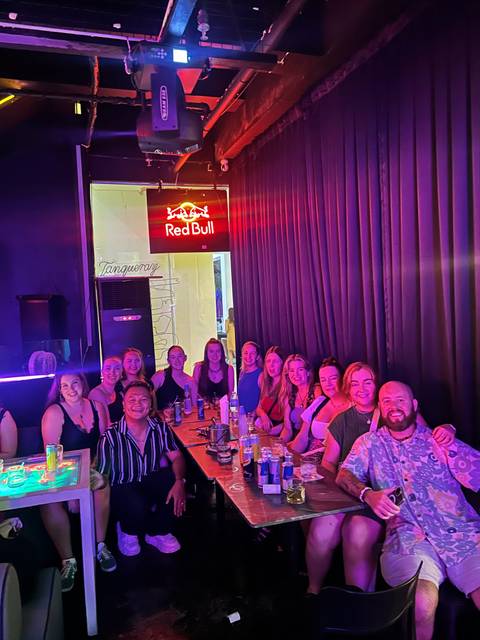 Group of people sitting in a bar with drinks.