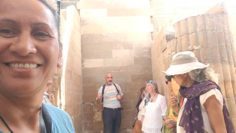 Group of people in an ancient structure, one person smiling at the camera.