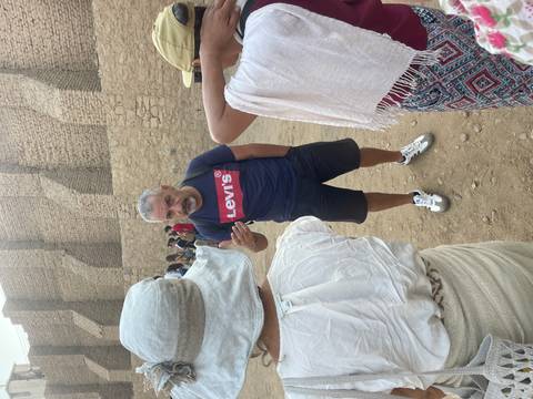 Tour guide speaking to a group near ancient ruins.