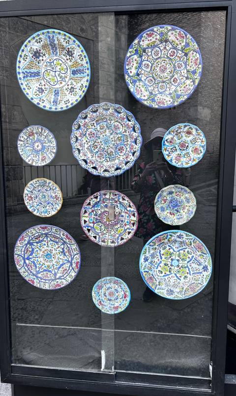       Display of decorative plates with colorful designs.
  