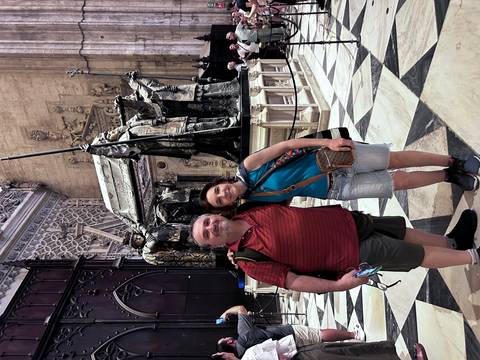       Couple posing in front of a tomb inside a historical building.
  
