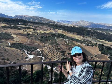       Woman posing with a scenic mountain landscape in the background.
  
