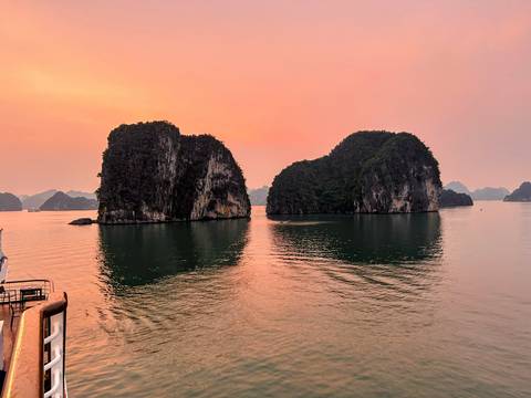       Sunset view of Ha Long Bay with rich colors reflecting on the water.
  