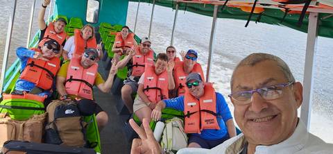 A group of people wearing life jackets on a boat.