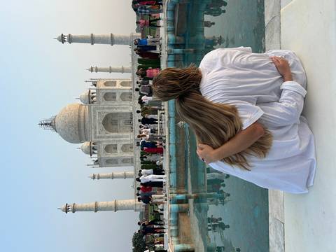      A couple sitting in front of the Taj Mahal.
  