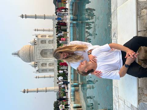       Couple embracing with the Taj Mahal in the background.
  