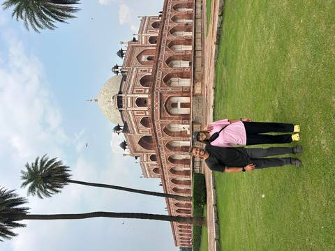       A couple standing in front of a large monument.
  