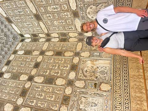       Couple in front of intricately decorated walls.
  
