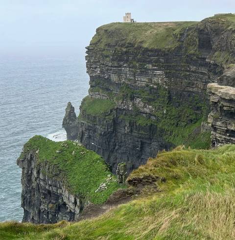       Cliffs over the ocean with lush greenery.
  