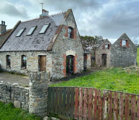       Stone building with surrounding ruins.
  