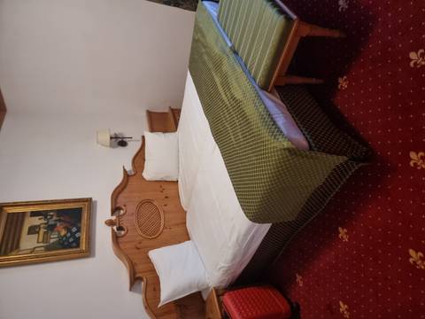       Traditional hotel room with wooden furniture.
  