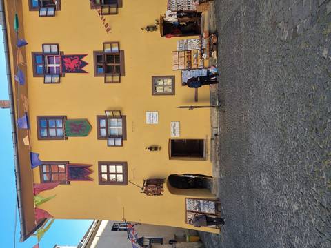      Colorful facade with banners and cobbled street.
  