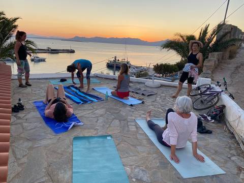 Group of people doing yoga with a scenic sea view.