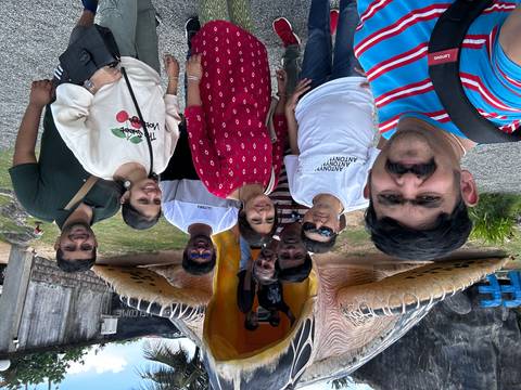Group of people standing in front of a large statue entrance.