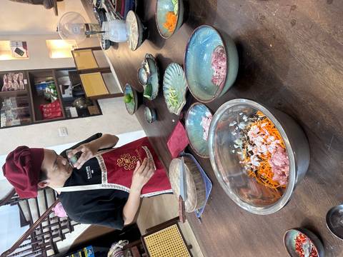 Cooking class setup with a person preparing ingredients for a Vietnamese dish.