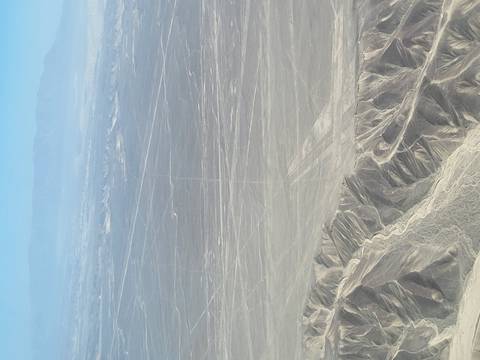 Aerial view of barren desert landscape with etched lines.