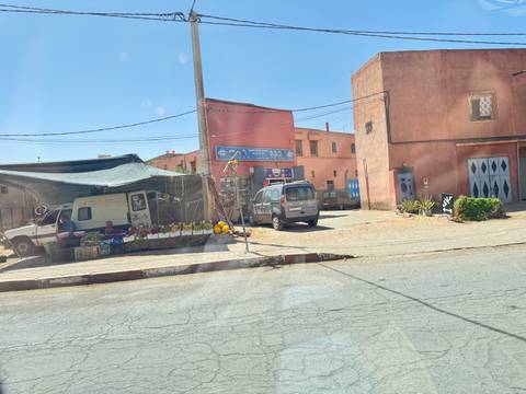       Street view of a small market with buildings.
  